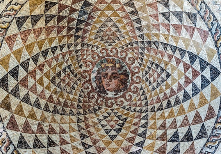 The face of Dionysus at the center of a mosaic in Corinth, Greece,