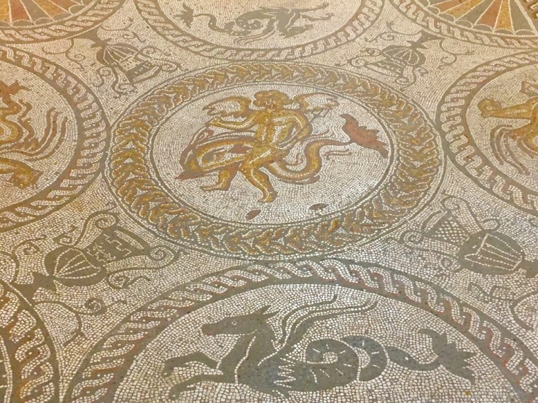 A mosaic floor representing Cupid riding a dolphin.