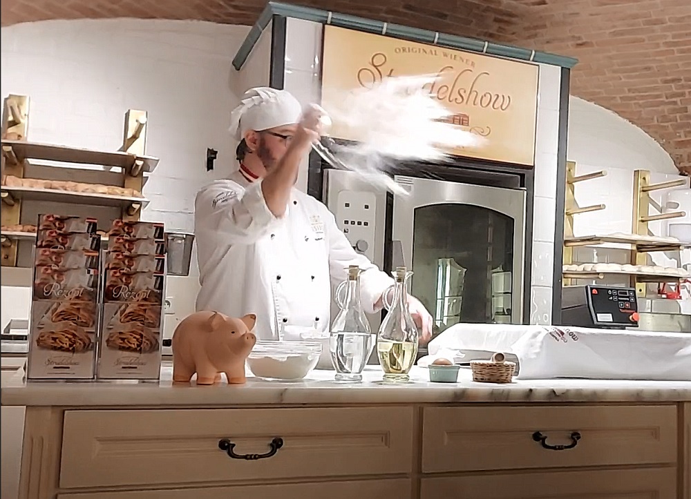 The confectioner is throwing flour on the board