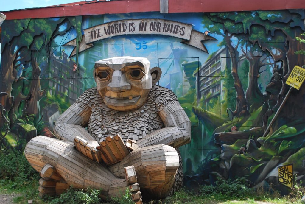 Large mural and wooden statue combo in Christiania Freetown, Denmark